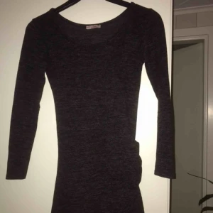  - Mörkgrå kortklänning med detalj på sidan, sitter jättesnyggt! Tjockare matrial så passar perfekr till t.ex nyårsfesten. Använd vid 2-3 tillfällen och inga defekter finns
