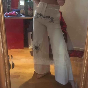  - vita högmidjade utsvängda jeans med avklippt kant, med detaljer jag ritat på med vattenfast penna, sparsamt använda, super sköna och inte stela alls, säljer eftersom ja knappt använder dom