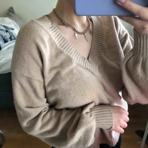  - En beige tröja från NA-KD X luisa lion. Super mysig neutral färgad tröja med ballong armar. V ringad och ribbade kanter. Super enkelt å stalla till allt, lagom tunn.🥰😚☺️🥳🏄🏼‍♀️🥰