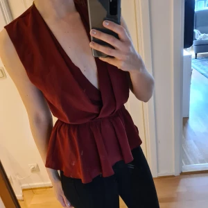 Topshop top - Mörkröd top från Topshop, snygg med eller utan bälte. Använd 3 gr. Frakt betalas av köparen, kan lämnas i Malmö. 