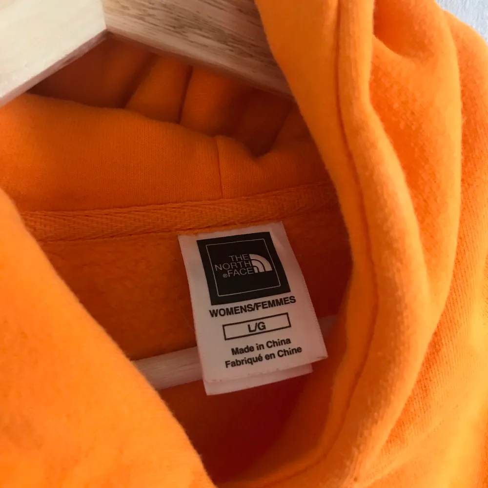 Orange hoodie med rosa tryck från The North Face. Storlek L men massage S-L. Mycket bra skick. Frakt ingår ej. SÄNKT PRIS 150kr‼️. Hoodies.