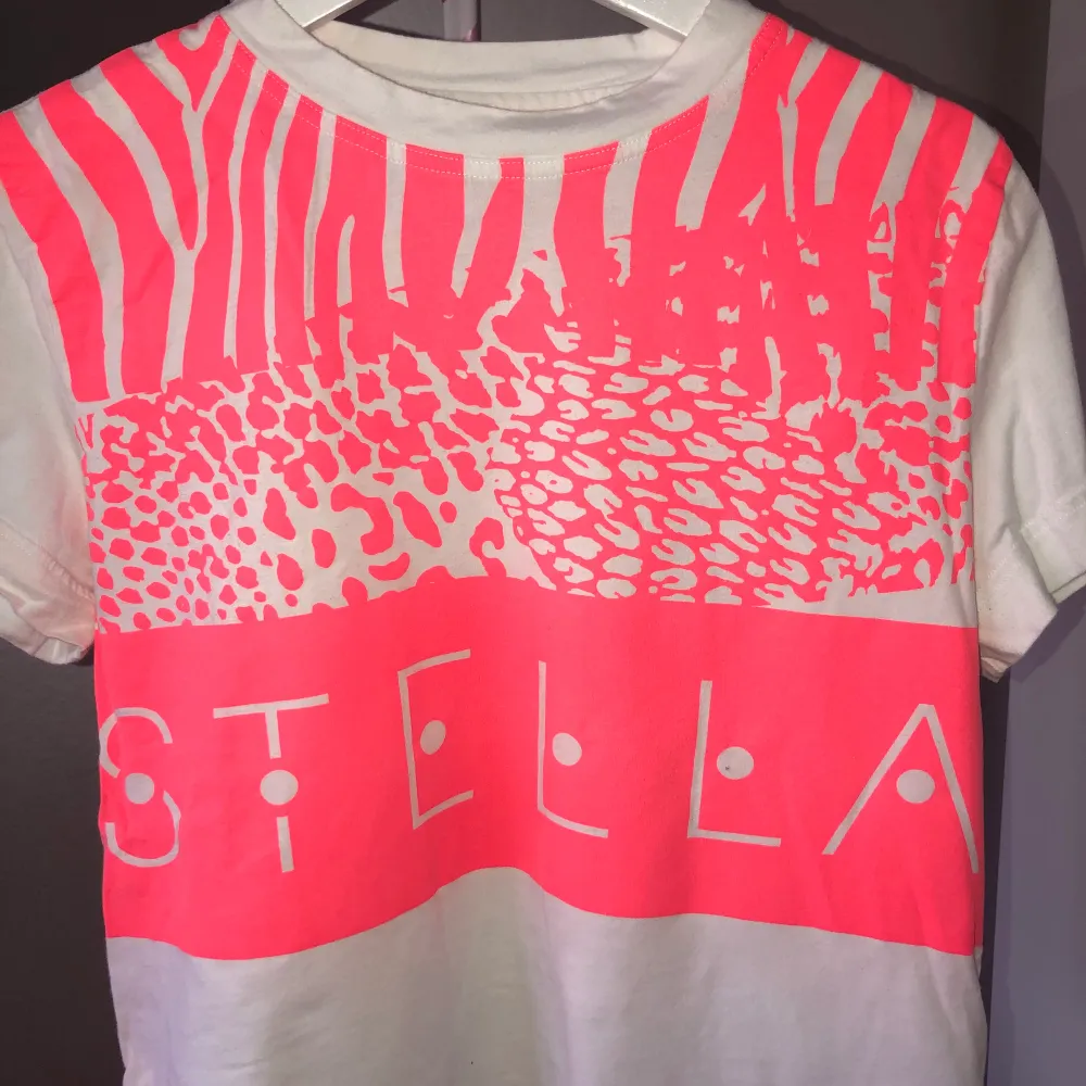 En cool T-shirt från Stella McCartneys kollektion med StellaSport. Har en dragkedja detalj på sidan, liten penna på kanten. Storlek S. Nypris ca 250kr. T-shirts.