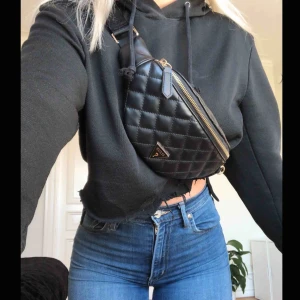  - Jättesnygg fannypack från Guess med knäppe och guldiga detaljer