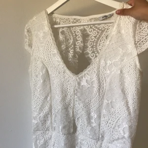 Vit spets student/skolavslutningsklänning fr ONLY - Superfin vit spetsklänning med v-ringning och öppen rygg. Perfekt till student/skolavslutning/sommaren. Endast använd ca 2 h, i nyskick! Går till knäna ungefär. Fråga efter bilder, samfraktar gärna! Kolla annonser för 10-100kr. Frakt tillkommer 💗⚡️