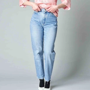 80-tals-jeans - Mom-jeans från Lee. Tajta i midjan, vidare kring lår och smalare nertill i härlig urtvättad blå. Innerbensöm 72 cm. Midja 66 cm. Frakt exklusive. 