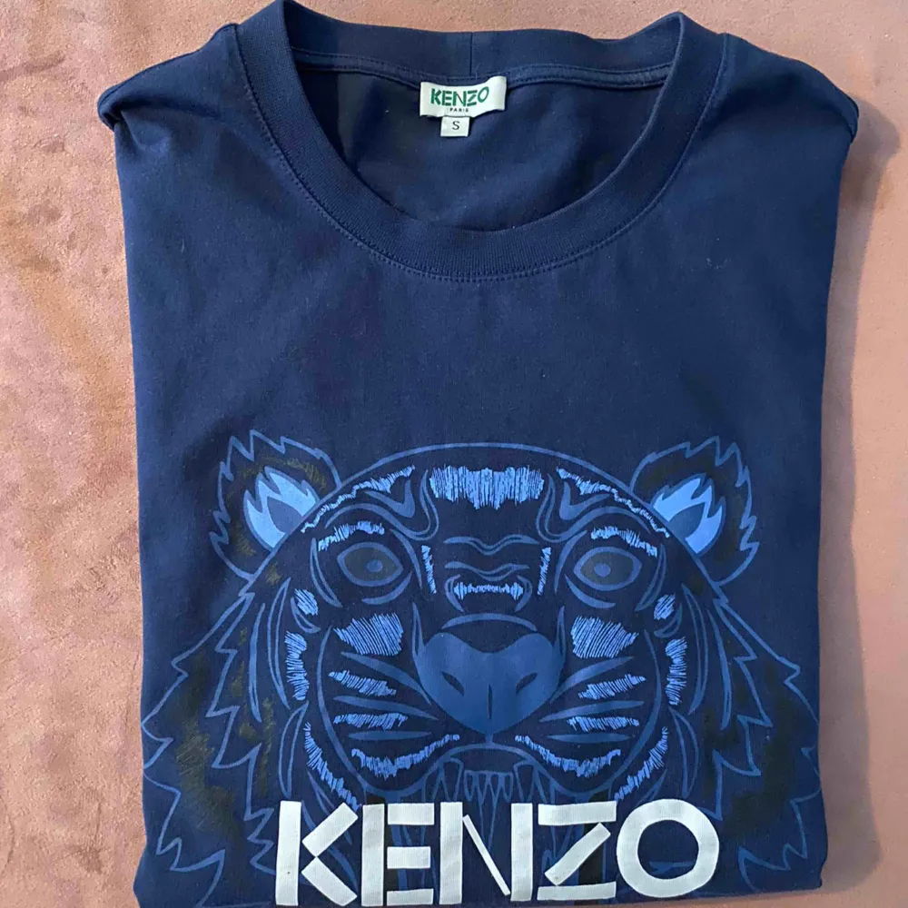 Blå tshirt med blå tiger från Kenzo. Plagget är i nyskick då den endast är använd ett fåtal gånger.. T-shirts.