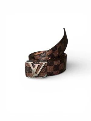 L&V rutigt brunt bälte - Snyggt bälte med klassiskt rutigt mönster i brunt och mörkbrunt. Bältet har en stor silverfärgad L&V-logga som spänne och är tillverkat i exklusivt skinn. Perfekt accessoar för att lyfta din outfit.