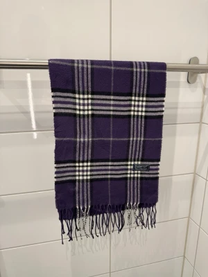 Burberrys Halsduk/Scarf Lila - Burberrys Halsduk / Scarf  Färg: Lila Material: 100% Lammull Unisex  Fint skick!
