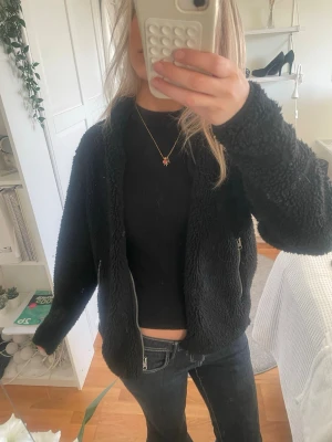Svart teddyjacka  - Mysig svart teddyjacka med dragkedja framtill och två sidofickor med dragkedja. Jättemysig och snygg vårjacka, säljer den då den inte kommer till användning, inga defekter och bara att höra av sig vid frågor 😊😊☀️