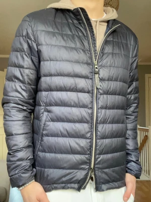 Woolrich quiltad cardigan jacka – strl S - Stilren quiltad cardigan/jacka från Woolrich i lätt och smidig modell. Perfekt som mellanlager eller tunn jacka under vår, höst och mild vinter. Väldigt clean och tidlös design som passar till allt.  Snygg både öppen och stängd. Funkar lika bra till vardag som mer uppklätt.  Öppen för bud! Skick: Mycket bra skick Storlek: S Färg: Mörkgrå/blå ton  Pris: 799 kr