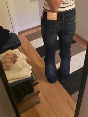 Low waisted  - Säljer ett par mörkblå bootcut jeans från Cheap Monday med klassiska bakfickor och kontrastsömmar. 
