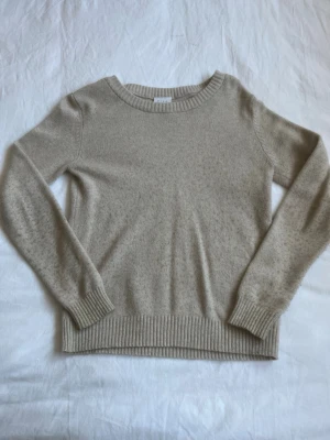 Beige stickad tröja - Mjuk och stilren beige stickad tröja. Tröjan har rund halsringning, långa ärmar och ribbade muddar vid ärmslut och nederkant. Perfekt basplagg i garderoben och enkel att matcha till olika outfits.