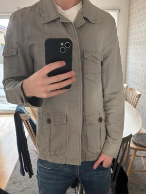 Overshirt från Devred - Stilren beige overshirt från Devred med klassisk krage och flera fickor framtill. Jackan har knappstängning och är tillverkad i ett mjukt bomullsmaterial. Perfekt för lager på lager och enkel att matcha med olika outfits.