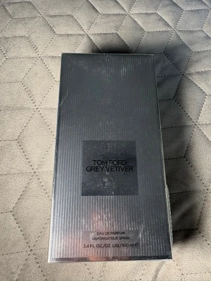 Tom Ford Grey Vetiver EdP 100ml - Tom Ford Grey Vetiver Eau de Parfum i en elegant, grå och silverfärgad förpackning. Flaskan rymmer 100 ml och doften är känd för sina fräscha, träiga och kryddiga toner. Perfekt för dig som gillar exklusiva och stilrena parfymer.