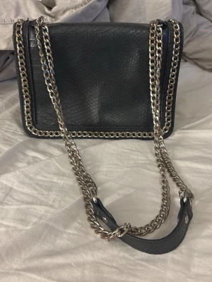 Svart handväska med kedjerem - 20cmx15cm. Den är vintage. Pris kan diskuteras 