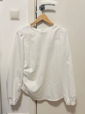 Vit elegant blus från SHEIN – Strl M, använd 2 gånger - Det Säljer en fin vit blus från SHEIN i storlek M. Blusen har en stilren design med fina puffärmar som ger en feminin och elegant look. Perfekt att bära till jeans, kjol eller kostymbyxor – passar både till vardag och festligare tillfällen.  ✨ Storlek: M ✨ Märke: SHEIN ✨ Använd endast 2 gånger ✨ Mycket bra skick  En tidlös och lättmatchad blus som passar extra fint under höst- och vintersäsongen med en stickad tröja eller kappa över. ❄️🤍