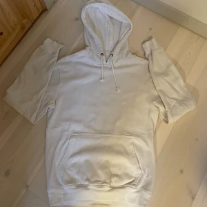 HOODIE | PIER ONE. - Säljer en stilren vit hoodie med stor magficka och dragsko i huvan. Hoodien har en klassisk passform och är perfekt för en avslappnad look. Materialet känns mjukt och bekvämt, och den neutrala färgen gör den lätt att matcha med andra plagg.
