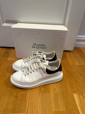 Vita Alexander McQueen sneakers - Säljer ett par vita sneakers från Alexander McQueen storlek 43 jätte fint skick lite tecken på användning men väldigt fina då dem har används få tal gånger allt og finns