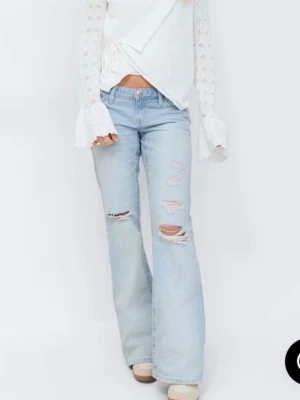 Ljusblå slitna bootcut jeans - Säljer ett par ljusblå bootcut jeans med slitningar och hål på benen. Använt 1 gång och gillade inte hur dem satt på mig så därav säljer jag dem, start pris 399.