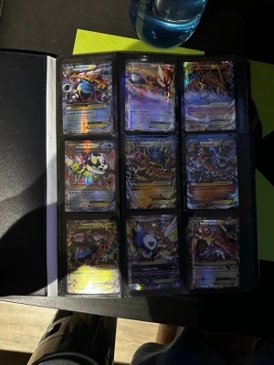 Pokémonkort i samlarpärm - Säljer en samling Pokémonkort i en svart samlarpärm. Korten är holografiska och visar flera olika Pokémon, bland annat Mega Mewtwo, Gardevoir och Charizard. Perfekt för dig som vill utöka din samling med coola och färgglada kort. Fick dom av min morbror så vet inte riktig hur mycket  dom är värda.