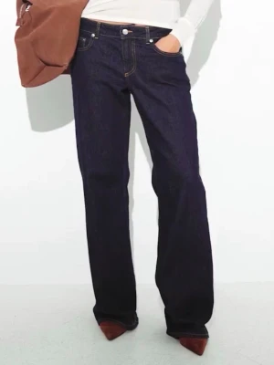 Jeans med låg midja - Säljer ett par mörkblå jeans med låg midja och vida ben. Klassisk femficksmodell med knapp och dragkedja framtill. Ända defekten visas på sista bilden, asså bara lite slitet längst ner på ena benet.