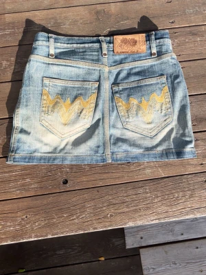 Blå jeanskjol  - Säljer en blå jeanskjol med gula detaljer på bakfickorna. Det är en fin kort kjol som inte kommer till användning och är strl 36 (s)