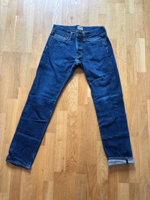 Edwin ED-75 Mid Rise Tapered Selvedge Jeans – W31 L34 - Säljer ett par premiumjeans från japanska Edwin i modellen ED-75 (Mid Rise Tapered). Klassisk mörkblå selvedge-denim med den snygga färgade kanten synlig vid myntfickan och om man viker upp bensluten. Modern passform med normal midja och ben som smalnar av nedåt. Märke: Edwin Modell: ED-75 Mid Rise Tapered Storlek: W31 / L34 Detaljer: Läderpatch baktill, broderade bakfickor, knappgylf. Skick: Bra skick använda i 2 månader så har lite nice streck och slitningar men många år kvar.