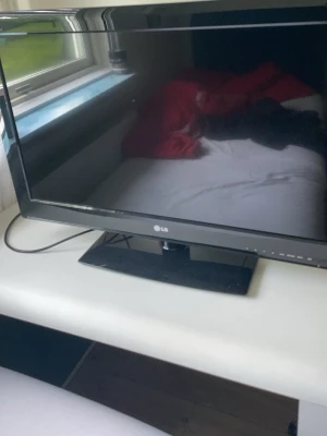 Svart LG TV med HDMI-ingång - Säljer en svart LG TV med platt skärm och stabil fot. TV:n har HDMI-ingång och flera andra anslutningsmöjligheter på baksidan. Perfekt för gaming eller som extra skärm till datorn. Klassisk design i plastmaterial.