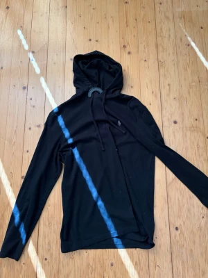 Svart hoodie från Polo Ralph Lauren - Snygg svart hoodie från Polo Ralph Lauren med klassisk huva och dragsko. Tillverkad i mjukt bomullsmaterial och har en liten broderad logga på bröstet. Perfekt för en chill och stilren look.