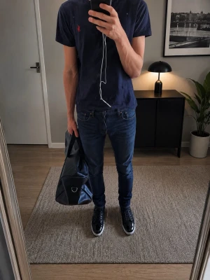 Mörkblå slim fit jeans från Replay - Anbass w29/l34 - Säljer ett par mörkblå slim fit jeans från Replay med klassisk femficksdesign och diskreta slitningar på låren. Jeansen har normal midja och raka ben, perfekta till sneakers eller boots. Materialet är mjukt och stretchigt för extra komfort.