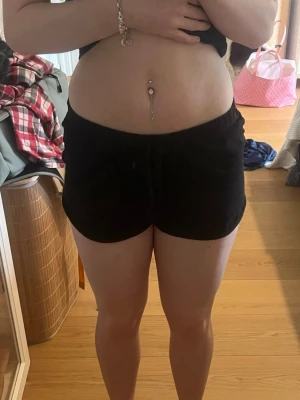 Svarta mjuka shorts med resårmidja - Säljer ett par svarta shorts med mjuk och stretchig resårmidja. De har en loose passform och är perfekta för varma dagar eller att chilla hemma. Materialet känns lätt och bekvämt mot huden. Använda men inga tecken på slitage. 