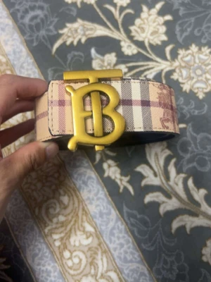 Beige och rutig Burberry-bälte - Säljer ett klassiskt Burberry-bälte i beige med det ikoniska rutiga mönstret. Och jag har boxen med tagen och påsen