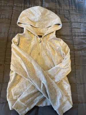 Juicy couture  - Säljer en fin grå tröja från Juicy couture eftersom den är för liten, byxor finns i separat annons på min sida, storlek M mycket bra skick! 
