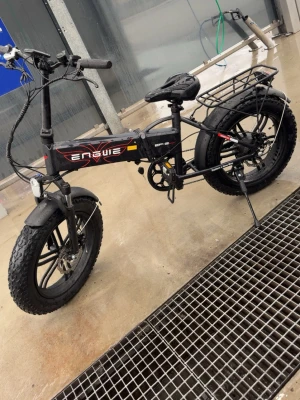 Svart elcykel Engwe EP-2 Boost - Säljer en svart elcykel av modellen Engwe EP-2 Boost med tjocka däck, hopfällbar ram och pakethållare bak. Cykeln har sportig design med röda och gula detaljer, bred sadel och robusta hjul. Perfekt för både stad och terräng. med ungefär 350Km På den