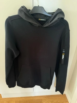 Svart hoodie från National Geographic - Hoodie från national geographic. Luvan är i ett annat material för en cool effekt, dragkedja på armen