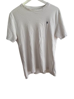 Vit t-shirt från Polo Ralph Lauren - Klassisk vit t-shirt från Polo Ralph Lauren med liten broderad logga på bröstet. Använd i ca 6 månader och storleken passar M men även S om man är lite emellan storlekarna!