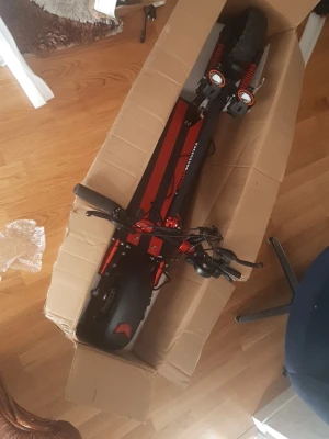 Svart och röd el-scooter med sadel - Elektrisk scooter från Joyor i svart och rött med bred fotplatta och sadel. Scootern har dubbla framlyktor, stötdämpare och robusta däck. Perfekt för att ta sig fram snabbt i stan. Laddare och stöd med följermed ytterdäck. Pris kan diskuteras  helt ny 