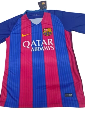 Barcelona Neymar Jr matchtröja 16/17 hemma - Säljer en FC Barcelona matchtröja från Nike med Neymar Jr och nummer 11 på ryggen. Tröjan har blå och röda vertikala ränder, klubbmärke på bröstet och Qatar Airways-tryck framtill. Tillverkad i lätt och ventilerande material, perfekt för fotbollsträning.