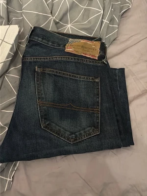 Mörkblå jeans från Denim & Supply Ralph Lauren - Snygga mörkblå jeans från Denim & Supply Ralph Lauren med klassisk femficksdesign och raka ben. Jeansen har slitningar och kontrastsömmar för en cool look. Perfekta till vardags och passar till det mesta i garderoben. Prisk kan diskuteras