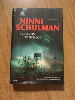 Svara om du hör mig av Ninni Schulman - En spännande kriminalroman av Ninni Schulman med hård pärm. Omslaget är mörkt med röd text och en mystisk skogsscen i grönt och svart. Perfekt för dig som gillar deckare och nervkittlande berättelser.