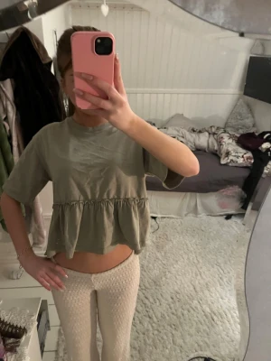 Grön volangtopp med kort ärm - Snygg grön topp med volang nertill och korta ärmar. Använd få gånger💞