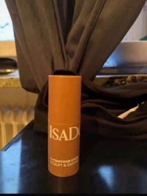 IsaDora Contour Stick Bronzer - Krämig bronzer i stickformat från IsaDora. Färgen är varm brun med en matt finish, perfekt för att skulptera och definiera ansiktet. Enkel att applicera tack vare den smidiga stiftformen. Förpackningen är cylinderformad i beige plast.