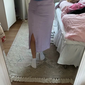 Ljuslila satinkjol med slits - Säljer en snygg ljuslila långkjol i satin med slits framtill. Den är använd få gånger men fortfarande i fint skick💜