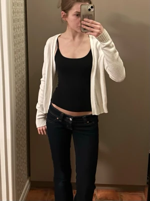 Vit öppen stickad kofta - Vit stickad kofta med öppen front och långa ärmar. Koftan har ribbade muddar och en enkel, clean design som är lätt att matcha med olika outfits. Jättemjukt och skönt material. Använd fåtal gånger 