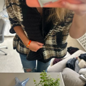 Oversized rutmönstrad stickad kofta - Säljer en oversized stickad kofta med rutmönster i svart, beige och vitt. Koftan har bred krage, kortare ärmar och två fickor framtill. Perfekt för lager på lager och en avslappnad look. Passar S-L❤️