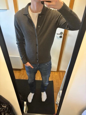  Cardigan  med knappar - Säljer en stilren mörkgrön/grå  kofta med knappar. Extremt snygg nu till våren. Inga fläckar eller hål m.m. Skriv vid funderingar!