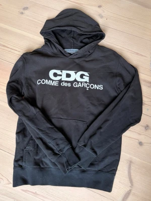 Svart CDG hoodie Comme des Garçons - Svart hoodie från Comme des Garçons, hör av er vid frågor, bra skick.