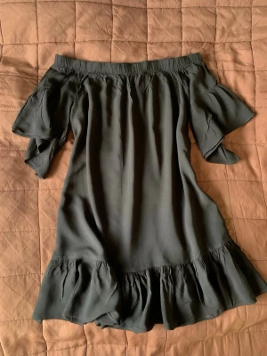 Off shoulder klänning - Gina Tricot - Svart off shoulder klänning från Gina Tricot, med volangdetaljer. Storlek 34. I mycket fint skick 🌸  Ser lite glansig ut på första bilden, men tyget är matt.