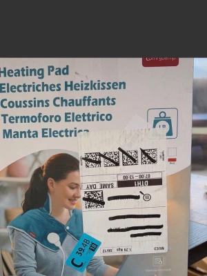 Elektrisk värmedyna blå - Elektrisk värmedyna i blått tyg med vita knappar och en kontroll. Dynan är formad för att ligga över axlar och nacke och har en sladd för anslutning. Passar perfekt för att värma upp kroppen under kalla dagar. Maskintvättbar.