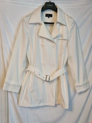 trenchcoat - Vit trenchcoat i storlek 40, använd fåtal gånger fint skick. Längd från axel ner är ca 81 cm.